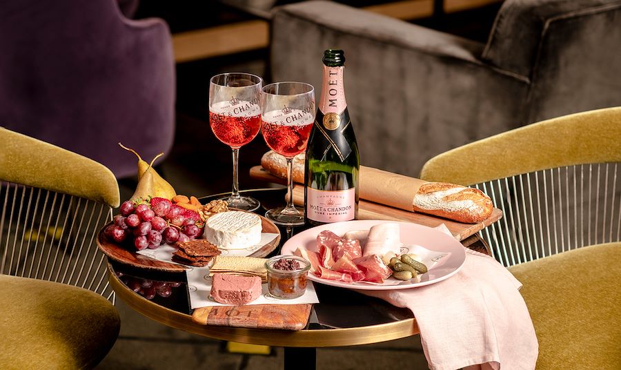 Hamper in park with a collection of charcuterie and Moët & Chandon Rosé Brut.
